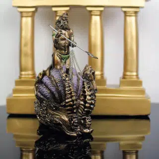 Photo d'une statue de Poseïdon debout sur un char composé d'un coquillage ouvert tiré par un hippocampe le tout devant quatre colonnes dorées