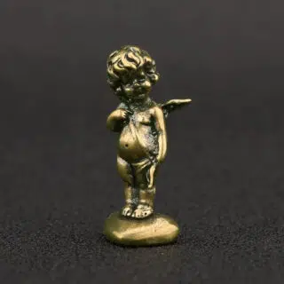 Statue doré d'un ange en cuivre perché sur un caillou