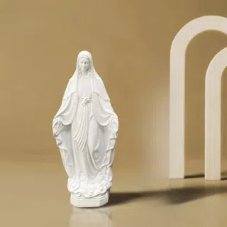 Statue de la vierge marie toute blanche dans une position dévotion