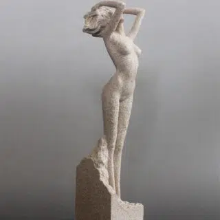 Statue de femme nue debout en pierre beige sur un socle