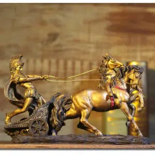Photo d'une satatue romaine représentant un char tiré par deux chevaux et un guerrier tirant sur les rênes sur un fond mordoré