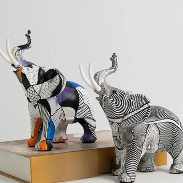 0-5f17df.jpeg 2 statue d'éléphant (rayé noir et blanc et coloré orange, bleu, violet et noir. Ils ont la trompe en l'air