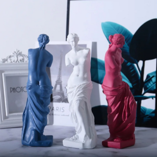 Statue de Vénus bleue, blanche et rouge devant un tableau de la Tour Eiffel