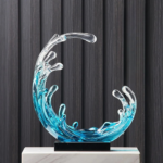 Statue bleu et traparente en forme de vague sur un socle noir