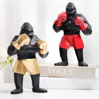 2 gorilles noirs en tenue de boxe rouge et dorée avec des gants de même couleur