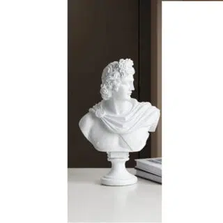 Photo d'une statue de buste d'Apollon blanche sur socle rond gravé à son nom en latin posé sur un meuble blanc sur fond noir