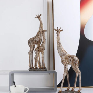 On voit trois statues de girafes modernes. L'une est avec son petit, l'autre seule.