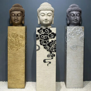 Photo de trois têtes de bouddha zen de couleur différente posées sur des colonnes assorties