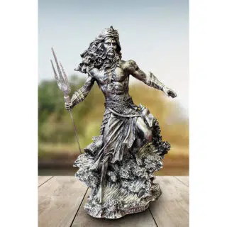 Photo d'une statue de Poséidon argentée debout sur l'écume d'une vague une jambe repliée et trident dans la main droite