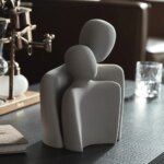 Statue abstraite d'un couple, l'un contre l'autre de couleur grise