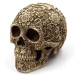 Statue de tête de mort sculptée avec des fleurs