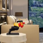 Statue de grosse femme jaune, rouge et noire en train de courrir