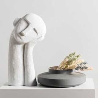 Statue de tête blanche avec un grand coup, la tête posée sur la main