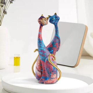 2 statues, de chat dans les coloris orangés. Ils sont placés l'un derrière l'autre.