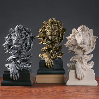 3 statue de tête de lion (doré, argenté et beige) avec une patte devant.