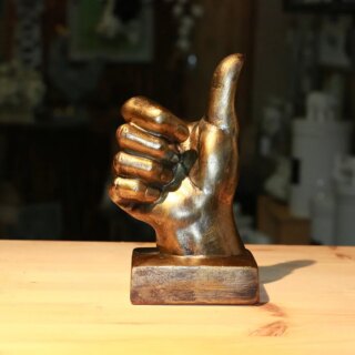 Statue main signe peace couleur bronze avec socle posée sur une table