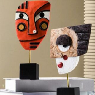 2 statues de visage (orange, blanc et marron)