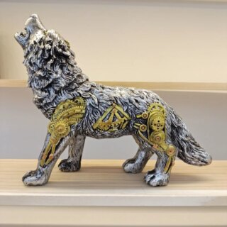 Statue de loup argenté posée sur un meuble.