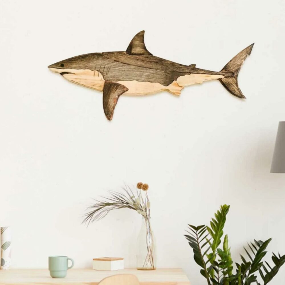 Statue de poisson en bois de 2 couleurs accroché au mur au dessus d'un bureau blanc