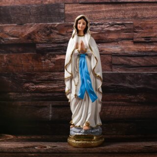 Statue de la verge marie en train de prier. Un grand voile blanc vient recouvrir une robe bleue
