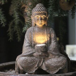 Photo d'une statue zen de bouddha assis éclairée la nuit