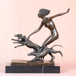 Photo d'une statue en bronze d'Artémis nue courant avec ses chiens sur socle de marbre et fond rose