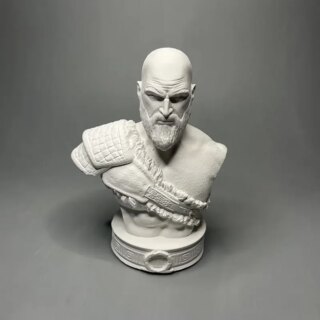 Photo d'une statue romaine buste d'un guerrier chauve et barbu avec double paulette sur la droite tenue en bandoulière sur un socle représentant une large ceinture à boucle le tout sur fond gris foncé