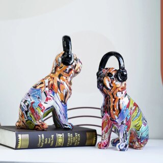 Deux statues de bouledogues pop art avec un casque de musique pour un style street art. L'une des statue est posée sur un livre