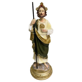 Photo d'une statue de Saint Joseph avec un bâton une couronne sur la tête, un gros médaillon doré sur la poitrine tenu par un collier de corde, vêtu d'une robe blanche couverte d'un habit vert et doré et un socle plat et rond le tout sur fond blanc