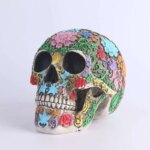 Statue de crâne de tête de mort sculptée et colorée