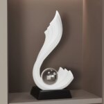 Statue en forme de vague blanche avec une boule transparente à sa base