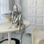 Statue de femme nue argentéer assise sur une table ronde