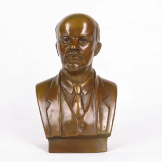 Sur fond blanc, on voit une statue du buste de Lénine couleur bronze